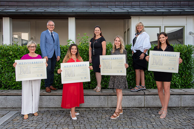 Stolz zeigen die Absolventinnen ihre Meisterbriefe in die Kamera.