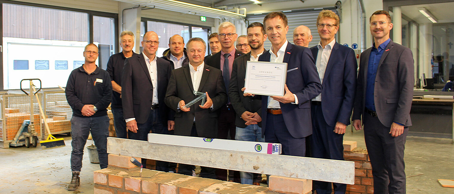 Ausbilder, Projektteam und VBG-Vertreter in der Maurerwerkstätte im Bildungszentrum Neumarkt. HWK-Vizepräsident Christian Läpple und stellvertretender HWK-Hauptgeschäftsführer Hans Schmidt nahmen Preis und Urkunde entgegen. Ausbilder, Projektteam und VBG-Vertreter in der Maurerwerkstätte im Bildungszentrum Neumarkt. HWK-Vizepräsident Christian Läpple und stellvertretender HWK-Hauptgeschäftsführer Hans Schmidt nahmen Preis und Urkunde entgegen.