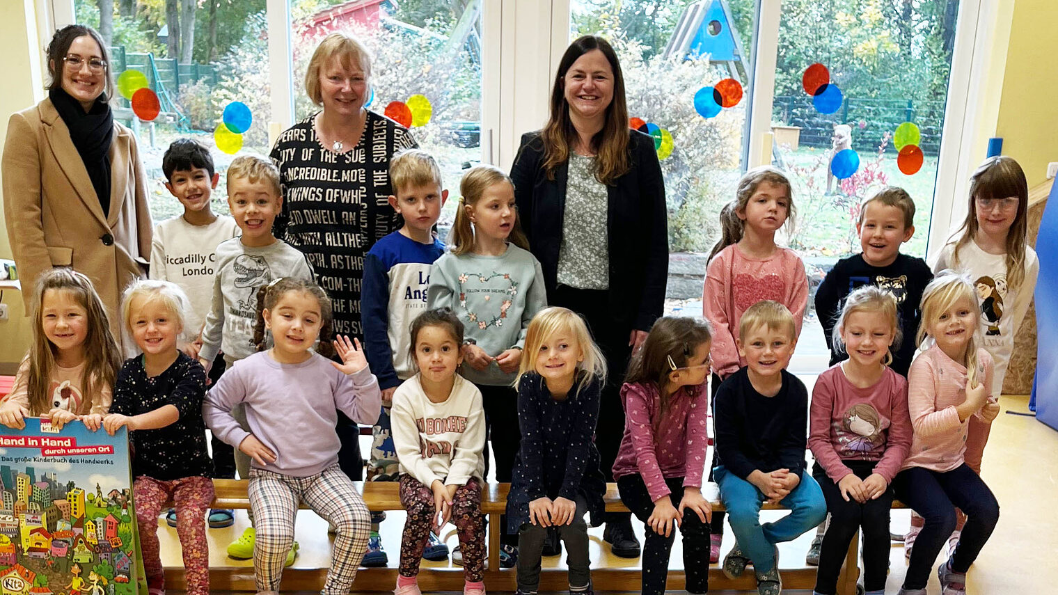 HWK-Vizepräsidentin Kathrin Zellner (re.) zu Besuch bei den "Bergzwergerln" in Cham, die stolz ihr selbstgemachtes Handwerksposter präsentieren.