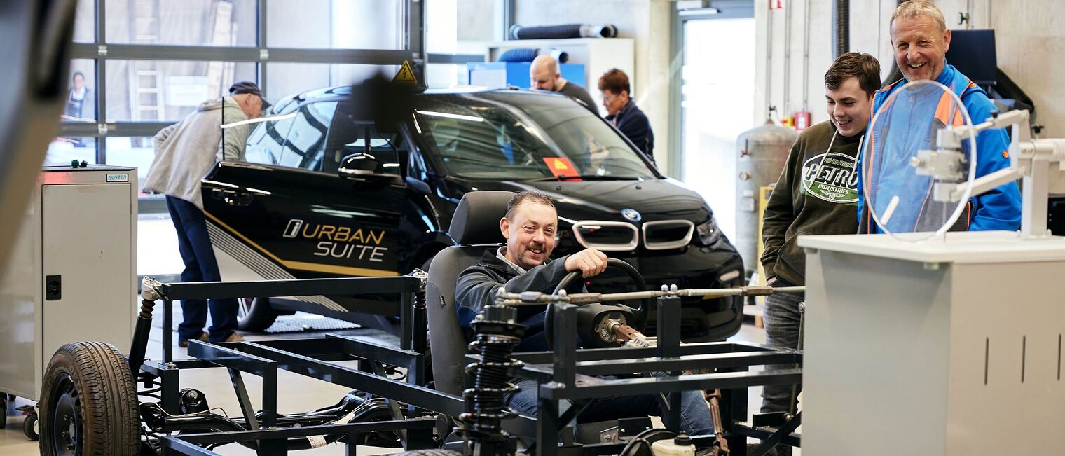 In den Kfz-Werkstätten des Bildungszentrums wurden laufend Geräte und Maschinen vorgestellt, die im Lehrbetrieb zum Einsatz kommen. Besucher in der Kfz-Werkstätte. Mann sitzt in einem Auto.