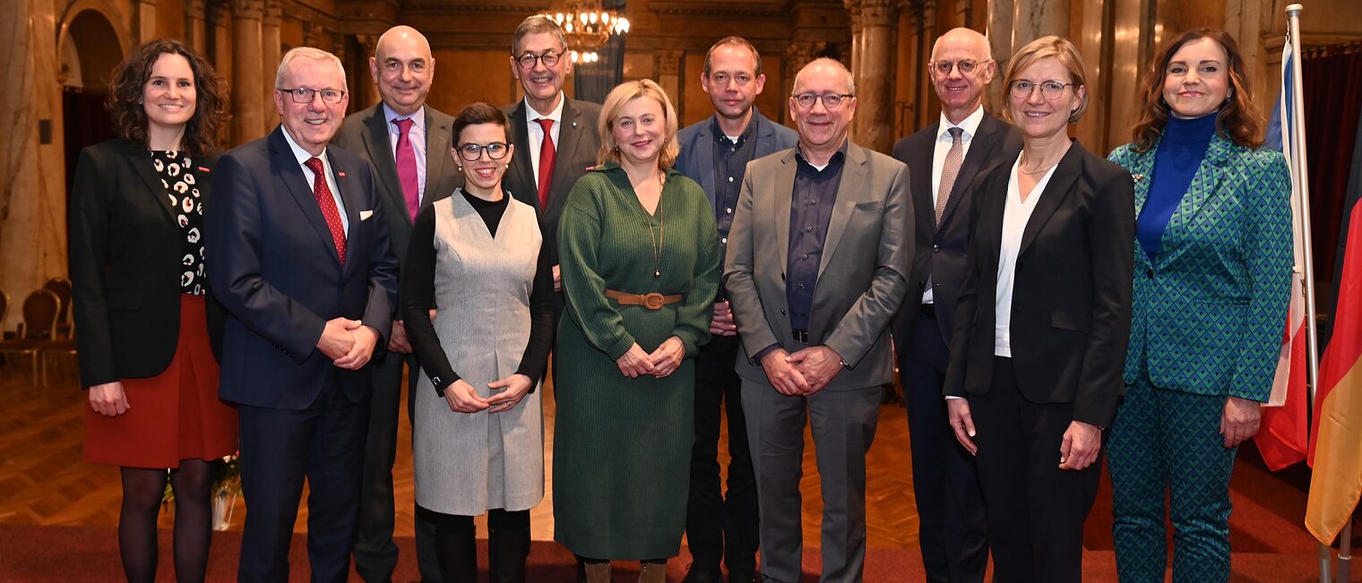 Männer und Frauen aus Handwerk und Wirtschaft stehen für ein Gruppenfoto zusammen.