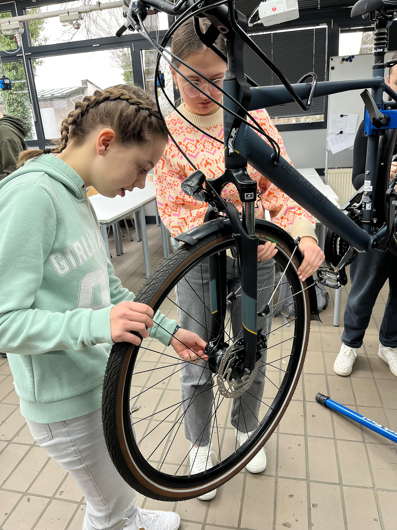 Zwei Mädchen flicken zusammen einen Fahrradschlauch.