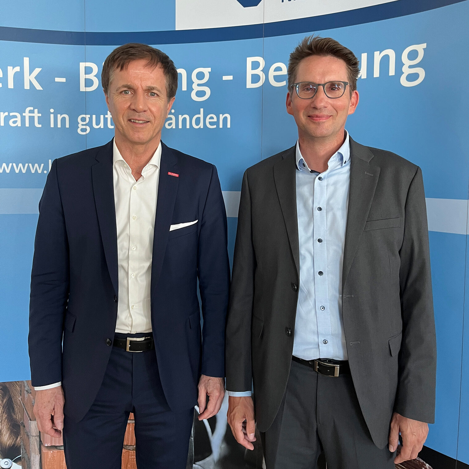 Hans Schmidt (HWK) und Ralf Kohl (IHK) stehen vor einer Pressewand. 