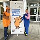 Eine verkleidete Maus und ein verkleideter Elefant stehen vor dem Roll-Up "Türen auf mit der Maus". 