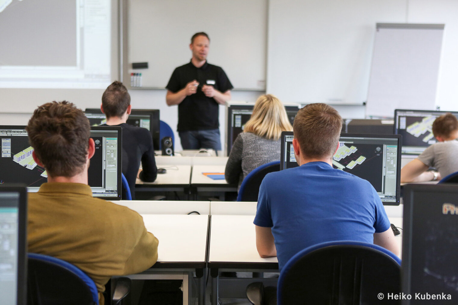 Eine dozierende Person hält einen Vortrag vor einer Klasse