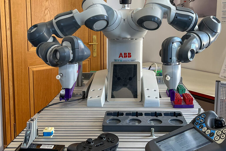 Darstellung eines ABB - kollaborativen Roboters mit zwei Armen auf Gestell.
