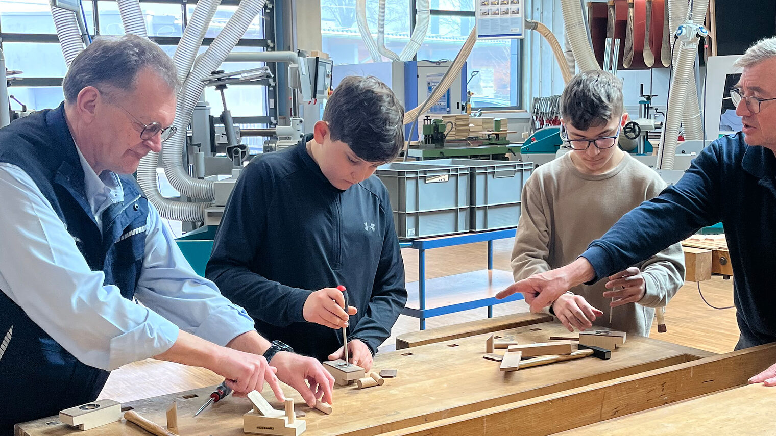 Zwei Schüler fertigten einen Flaschenöffner in Hobelform als Andenken an. Der Leiter des Bildungszentrums stand ihnen zur Seite. 