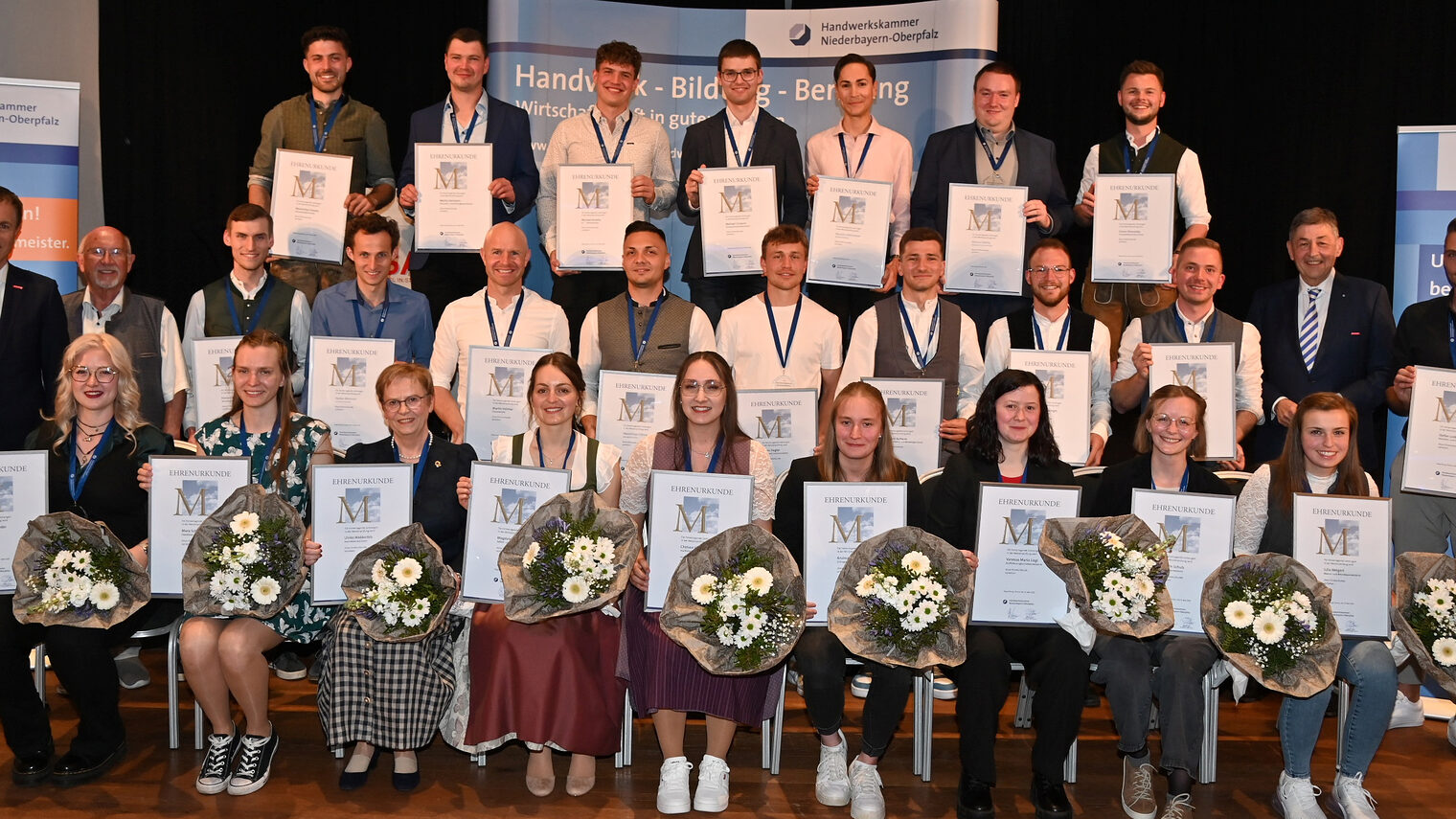Gruppenbild der jahrgangsbesten Handwerksmeister 2024/2025 mit ihren Medaillen und Urkunden bei der Ehrung in Straubing. 