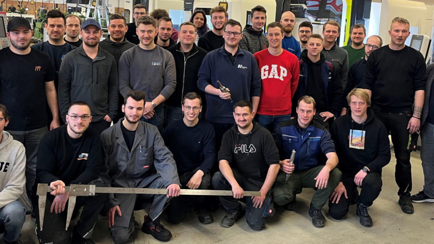 Ein Gruppenbild mit den Meisterprüfungsabsolventen im Feinwerkmechanikerhandwerk in der Werkstatt mit ihrem Kursleiter Wolfgang Meyer.