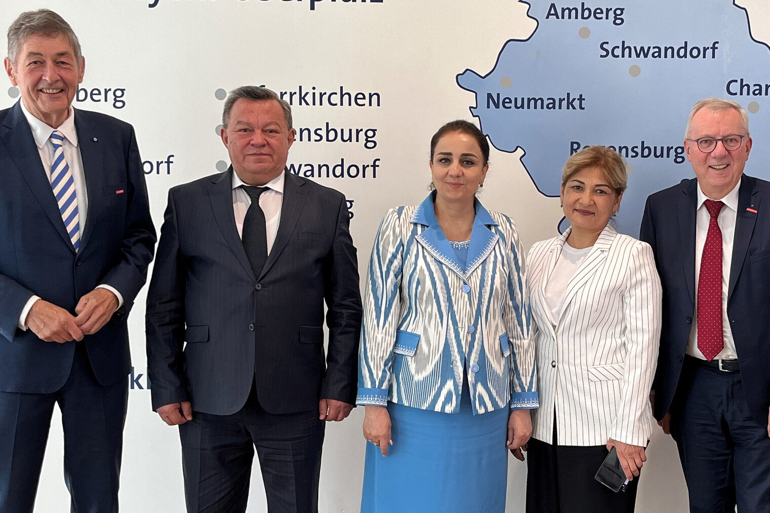 Die Handwerkskammer Niederbayern-Oberpfalz empfing tadschikische Gäste. Sechs Personen, darunter Vertreter der Handwerkskammer, stehen in formeller Kleidung vor einer Karte der Region Niederbayern-Oberpfalz.