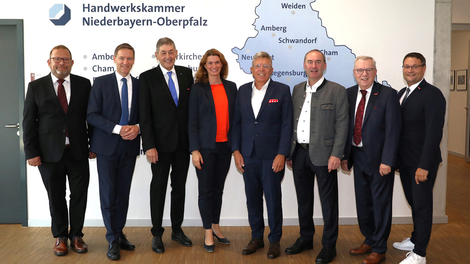 Die Ehrengäste der Festveranstaltung stellen sich vor der Wand mit der Karte von Niederbayern und Oberpfalz für das Foto auf. 