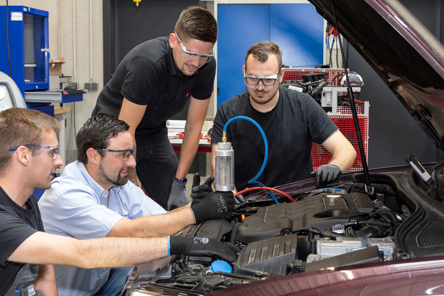 Einer der beliebtesten Ausbildungsberufe im ostbayerischen Handwerk ist in diesem Jahr der Kfz-Mechatroniker. Drei Auszubildende im Kfz-Mechatronikerhandwerk untersuchen mit ihrem Ausbilder ein Auto in der KFZ-Werkstatt.
