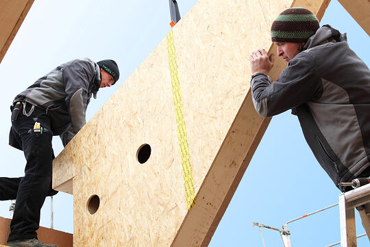 Auch das Bauhauptgewerbe verzeichnet im dritten Quartal in Teilen einen Rückgang bei den Auftragseingängen. Zwei Zimmerer stellen einen Dachstuhl auf.