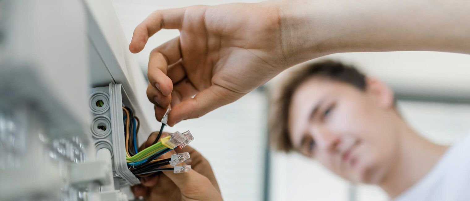 Ein Auszubildender verdrahtet Kabel.