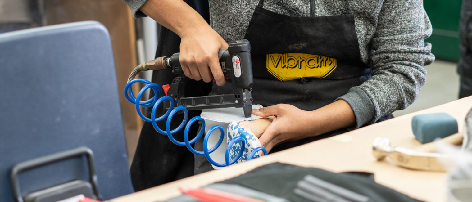 Ein Azubi passt eine Einlage an eine Leiste an.