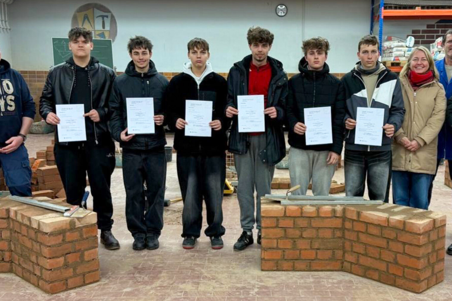 Tschechische Teilnehmer des Schüleraustauschs mit Lehrern, dem Direktor der Baufachschule und HWK-Ausbilder in der Bauhalle.
