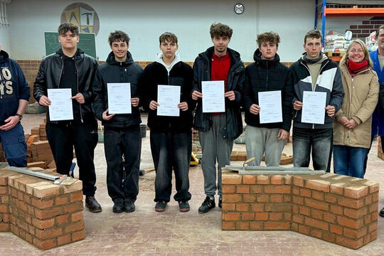 Tschechische Teilnehmer des Schüleraustauschs mit Lehrern, dem Direktor der Baufachschule und HWK-Ausbilder in der Bauhalle.