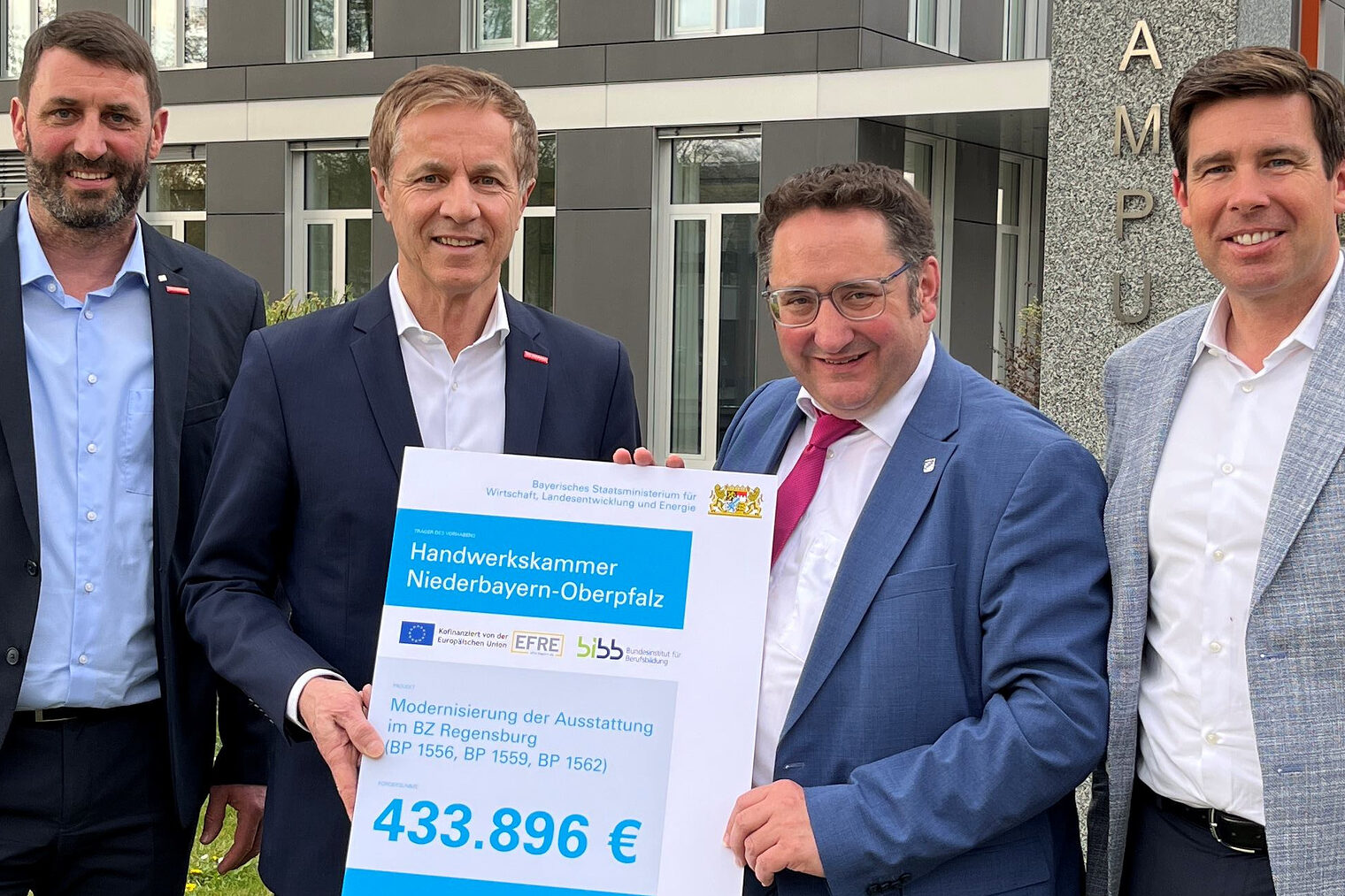 Bayerns Wirtschaftsstaatssekretär Gotthardt überreicht im Beisein von MdL Grossmann den Förderbescheid für ergänzende Ausstattungen an HWK-Vertreter Schmidt und Spiegler vor der Handwerkskammer.