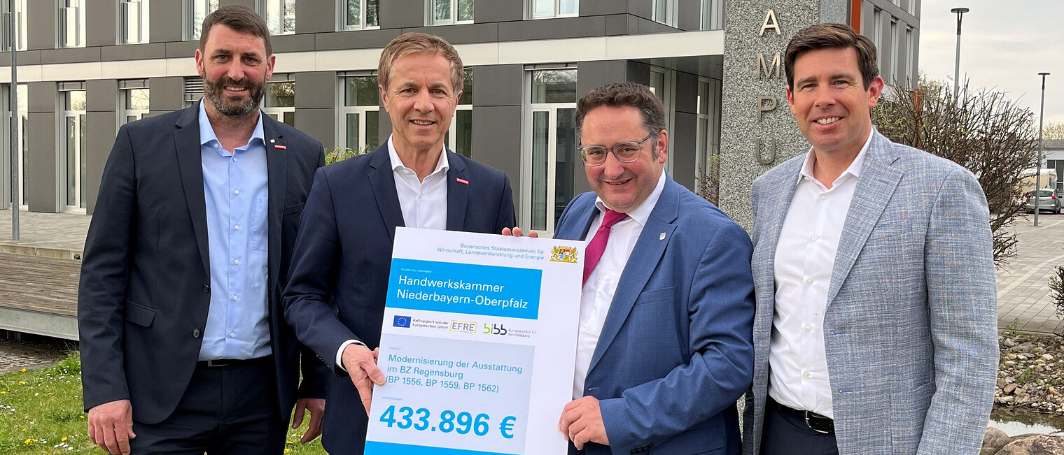 Bayerns Wirtschaftsstaatssekretär Gotthardt überreicht im Beisein von MdL Grossmann den Förderbescheid für ergänzende Ausstattungen an HWK-Vertreter Schmidt und Spiegler vor der Handwerkskammer.