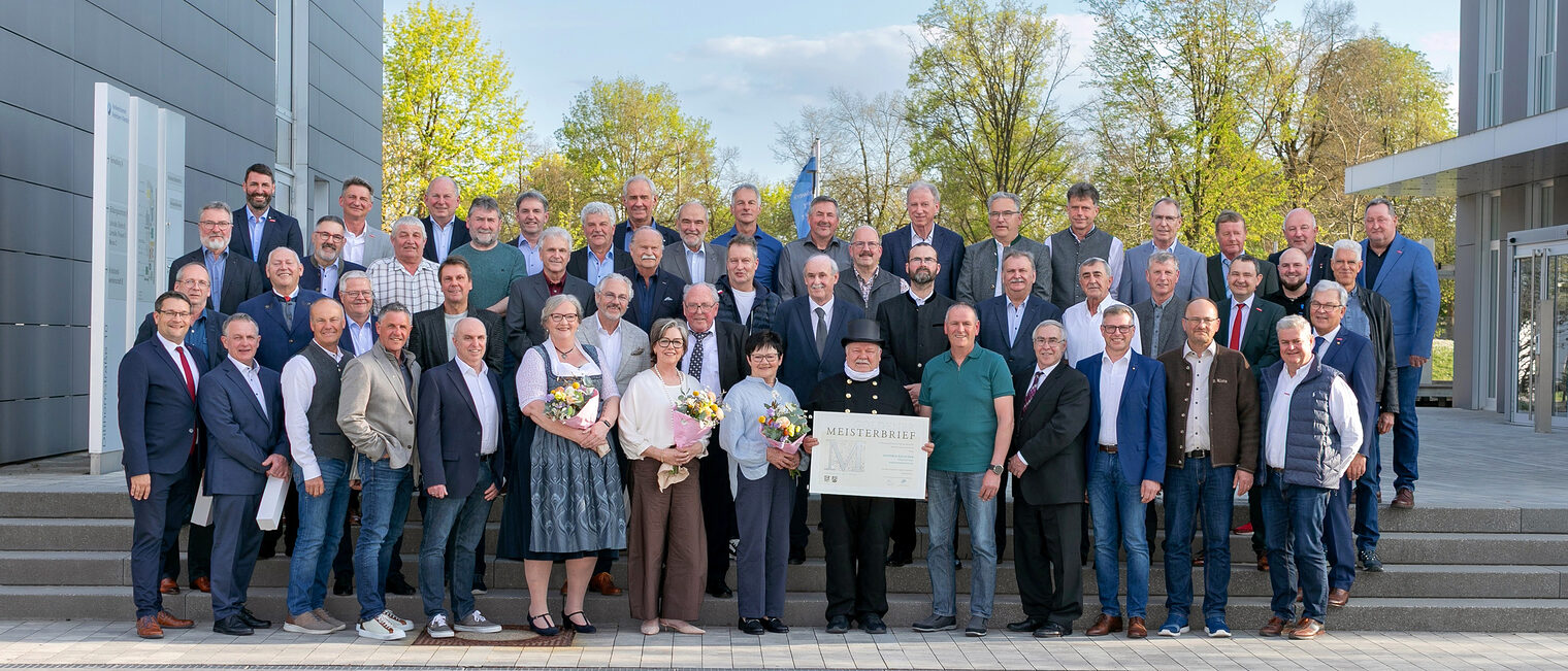 46 Handwerksmeisterinnen und Handwerksmeister mit HWK-Vertretern vor der Handwerkskammer bei der Verleihung der Goldenen Meisterbriefe.