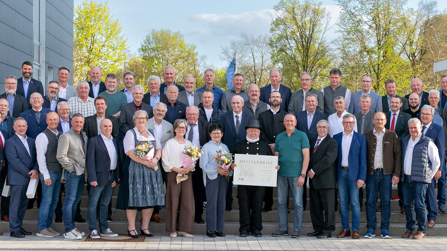 46 Handwerksmeisterinnen und Handwerksmeister mit HWK-Vertretern vor der Handwerkskammer bei der Verleihung der Goldenen Meisterbriefe.