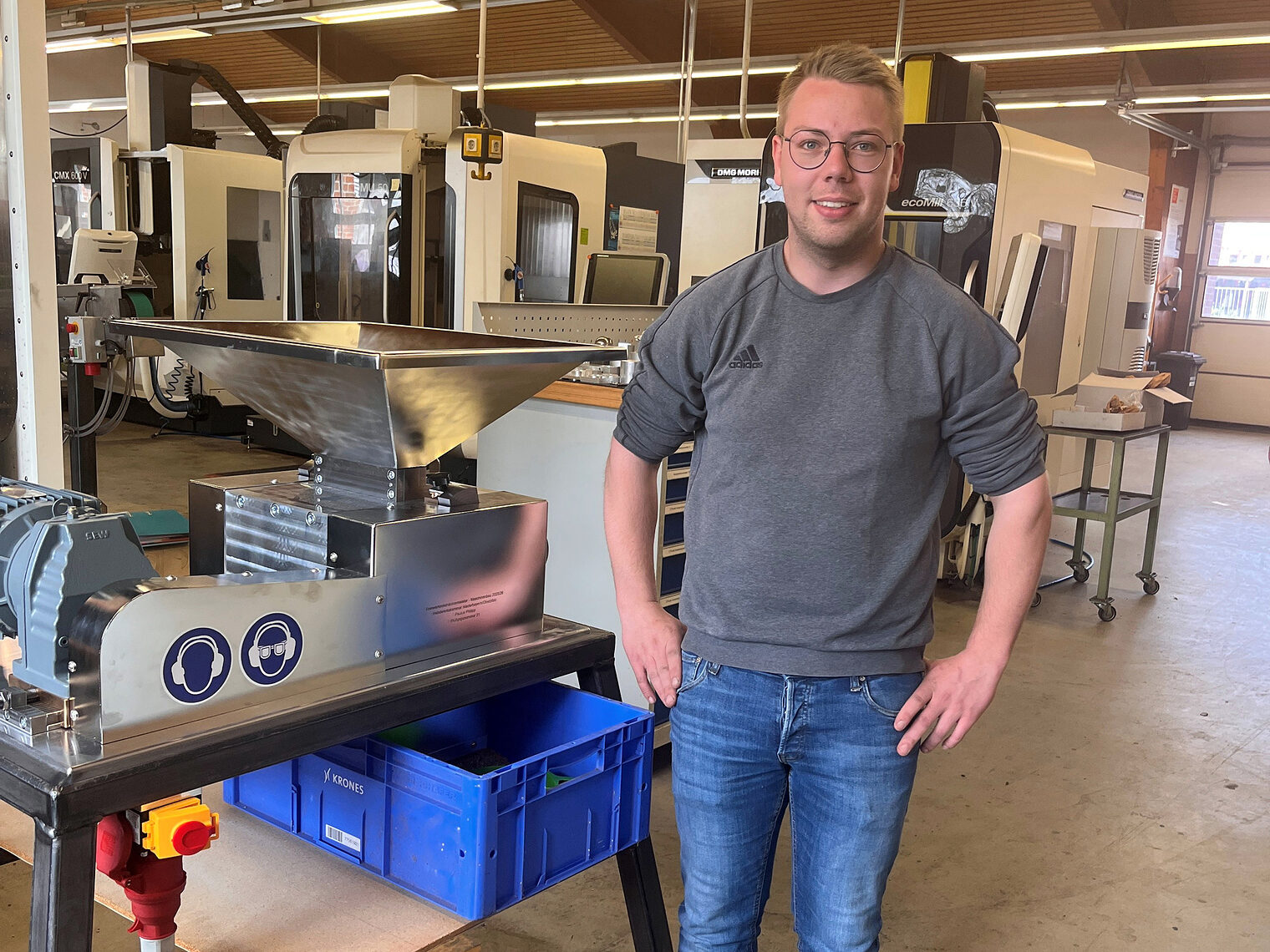 Kursbester Philipp Paulus steht neben seinem Meisterstück - einer Quetschmühle für Getreideerzeugnisse.