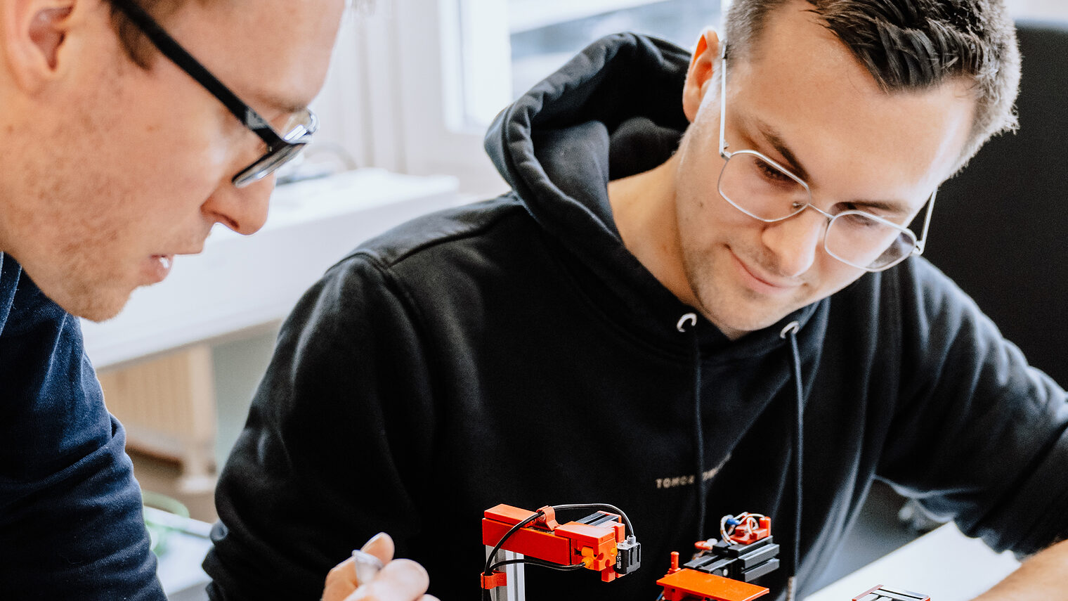 Zwei Meisterschüler tüfteln an einer Elektrokonstellation.
