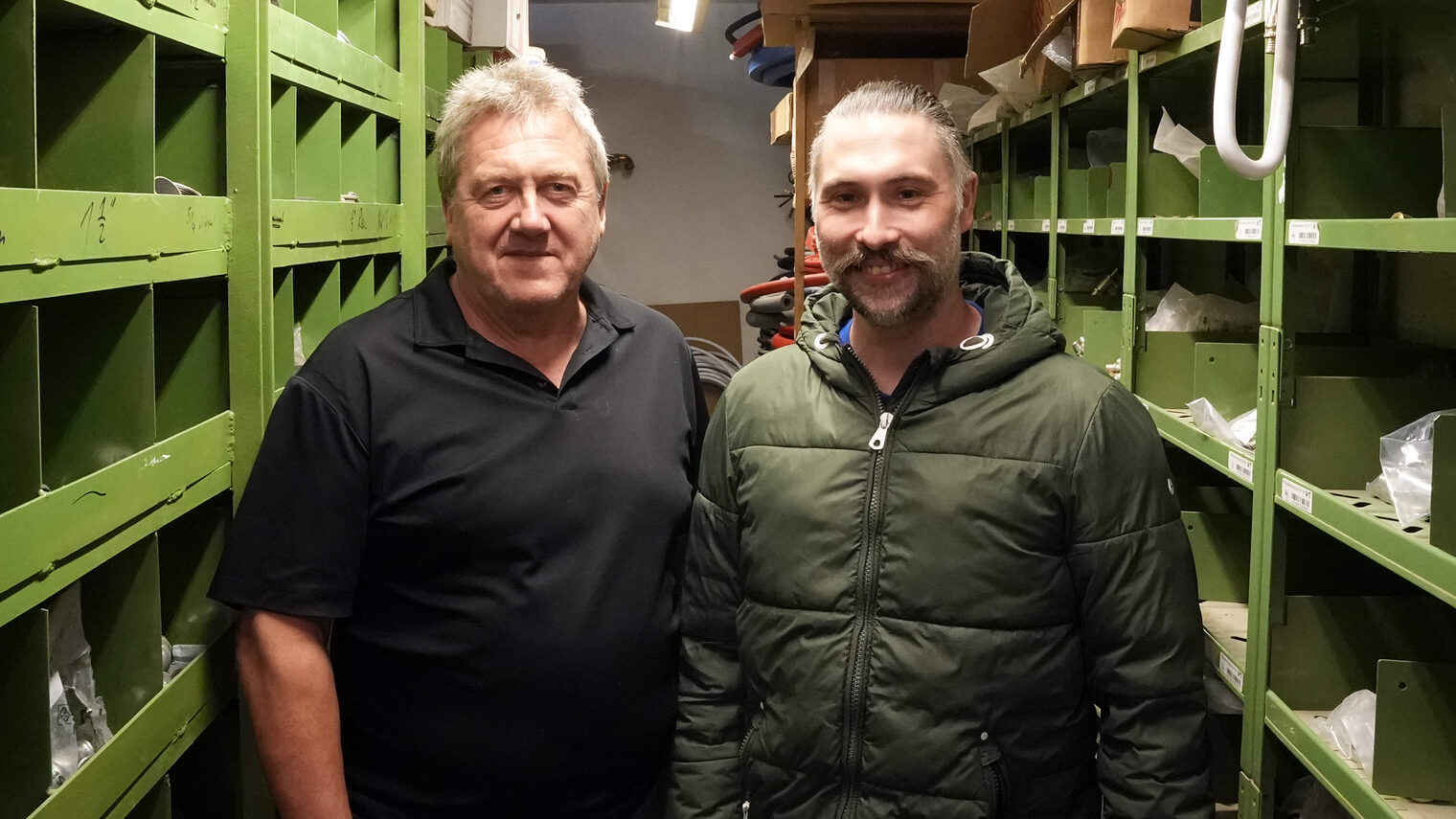 Josef Schauer übergab seinen Betrieb an Marcel Anzenberger. Sie stehen gemeinsam in der Werkstatt und posieren für das Bild. 